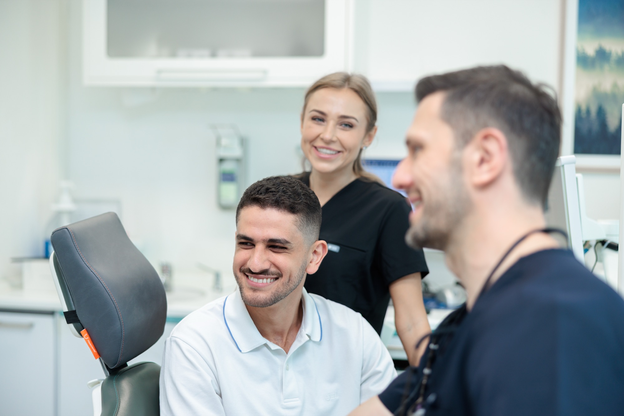 Prophylaxe-Team mit Patientin im Behandlungszimmer